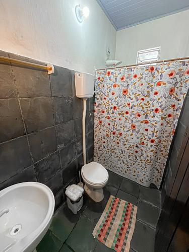 a bathroom with a toilet and a sink at Casa Maria Flor Guest House in Itacaré