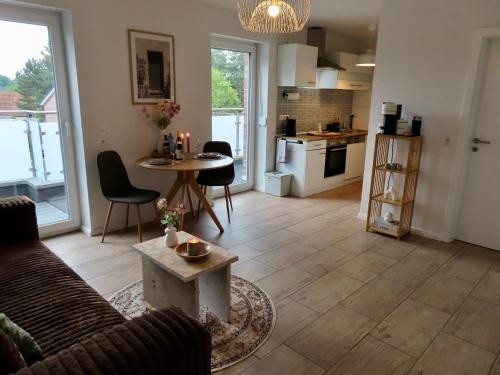 a living room with a couch and a table and a kitchen at Home & Apart - Apartment mit Stil & Wohlfühlambiente in Oldenburg