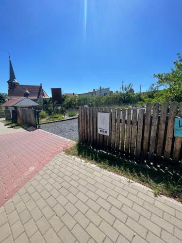 a sign on a fence next to a brick sidewalk at Projekt Przełazy in Przełazy