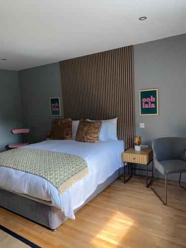 a bedroom with a large bed and a chair at The Snug at the BH 