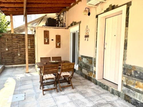 a wooden table and chairs on a patio at Olea Central Stay in Nea Kalikratia
