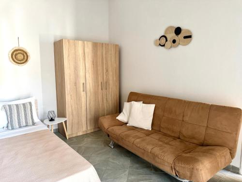 a living room with a brown couch and a cabinet at Olea Central Stay in Nea Kalikratia