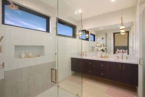 a bathroom with two sinks and a glass shower at Hale Mahina Hou in Koloa