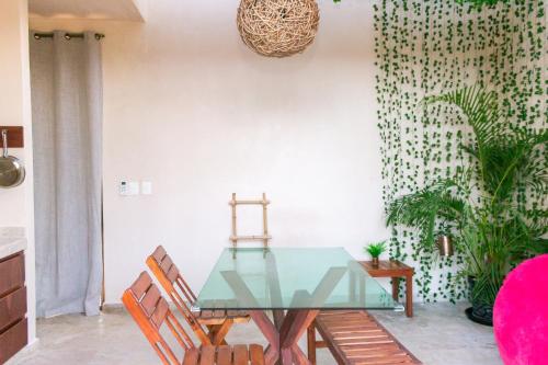 a dining room with a glass table and chairs at Pent House - Santuario Apartments in Chemuyil