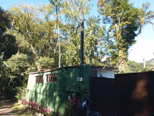 ein Zaun vor einem Haus mit einem Tor in der Unterkunft Chalé da Sheila in São Sebastião