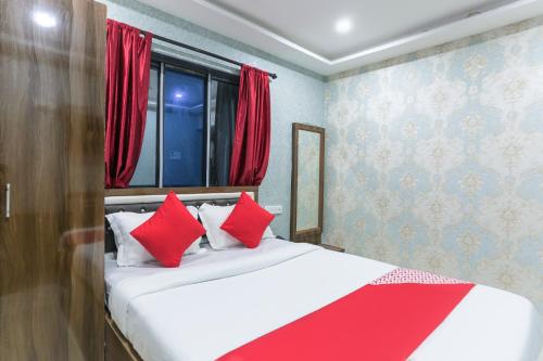 a bedroom with a large bed with red pillows at Super Hotel O Dk Inn Near Kalighat Kali Temple in Kolkata