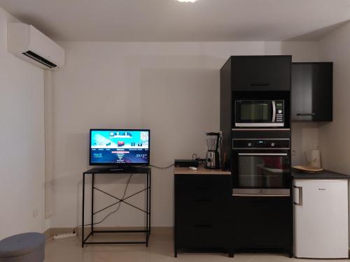 Il comprend une petite cuisine équipée d'une télévision et d'un four micro-ondes. dans l'établissement Grand Studio à 300m de la plage dans Résidence calme - une seule pièce, à Gruissan