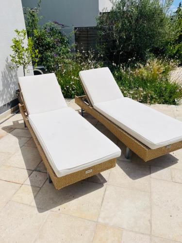 a pair of wicker beds sitting on a patio at House in Pezinok with swimming pool, Bratislava in Pezinok