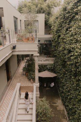 a woman walking down the stairs of a building at Casa Seis Siete in Mexico City