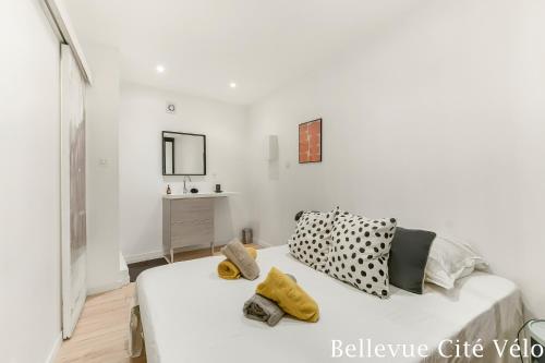 a white room with a bed with pillows on it at Les Bellevue Cité Trivalle "3 Apartments, 1 with Terrace & Private Parking, Aircon, WiFi, 500m from Cité, free public car park 200m" in Carcassonne
