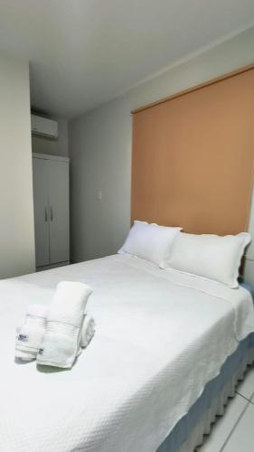 a large white bed with two towels on it at Pousada HAI in Fernando de Noronha