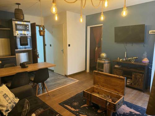 卢尔德Le Corsaire的客厅配有桌子、沙发和电视。