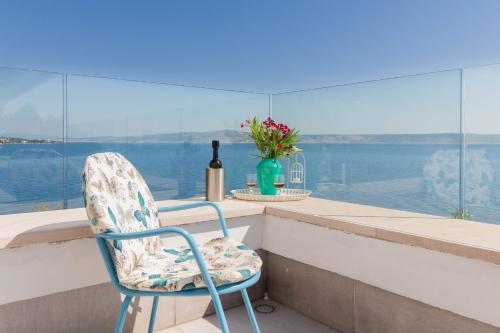 a chair sitting on a balcony with a bottle of wine at Morska vila Sanja in Starigrad-Paklenica