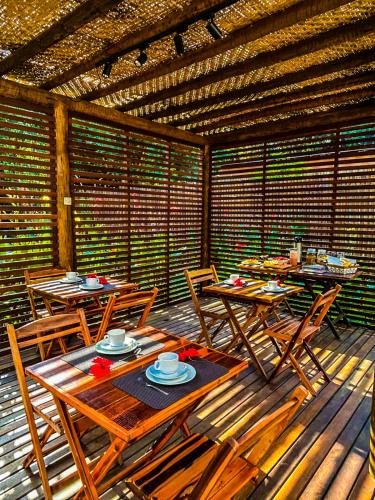 a patio with tables and chairs on a wooden deck at Pousada HAI in Fernando de Noronha