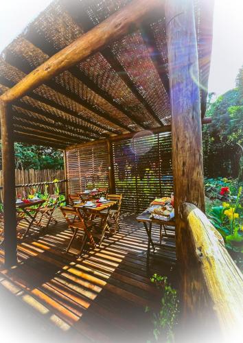 a patio with tables and chairs under a pergola at Pousada HAI in Fernando de Noronha