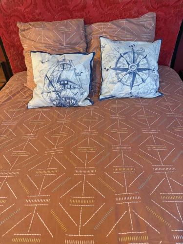 un lit avec deux oreillers dessus dans l'établissement Le Corsaire, à Lourdes