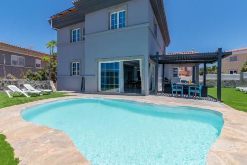 a swimming pool in front of a house at Villa Edén House by Maspalomas Holiday Villas in Maspalomas