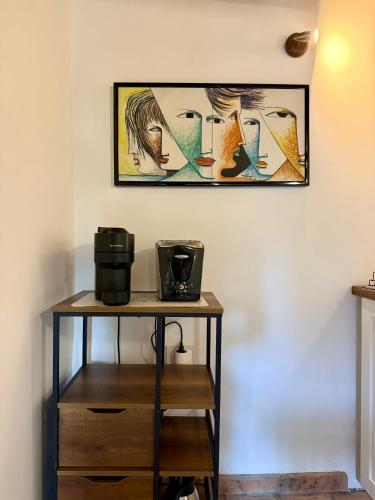a table with a coffee maker and a picture on the wall at Villa Bovari - Appia Antica in Rome