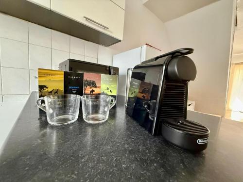 a kitchen counter with two cups and a coffee maker at Spitaki 'The Little House by the beach' in Voroklini