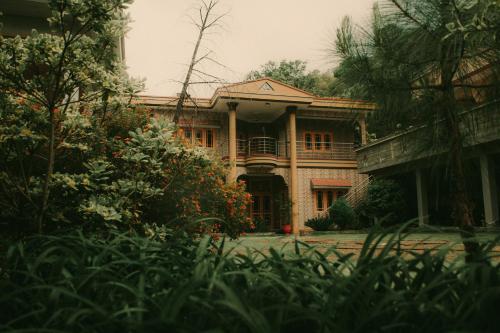 a large brick house with a balcony in front of it at The Mountain Retreat, Muzaffarabad - Families Only in Muzaffarabad