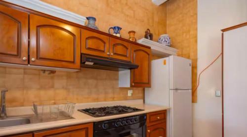 a kitchen with wooden cabinets and a white refrigerator at Bamboo Kira Pool in Chiconcuac