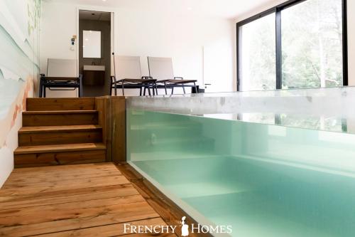 - une piscine dans une chambre dotée de parquet dans l'établissement Villa neuve Piscine intérieure 18pers, à Gujan-Mestras