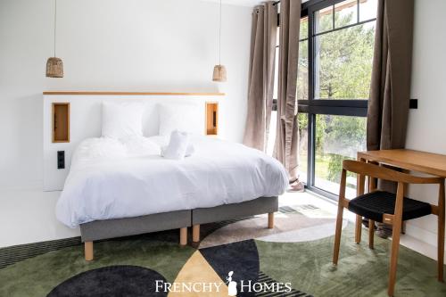 une chambre avec un lit, un bureau et une fenêtre dans l'établissement Villa neuve Piscine intérieure 18pers, à Gujan-Mestras