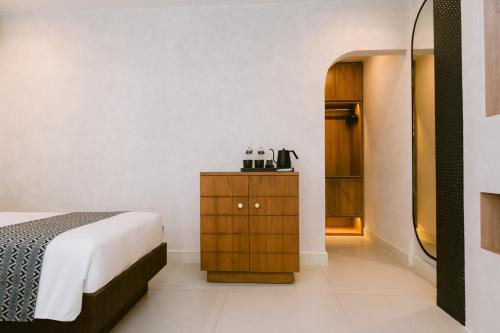 a bedroom with a bed and a wooden cabinet at Legong Keraton Beach Hotel in Canggu
