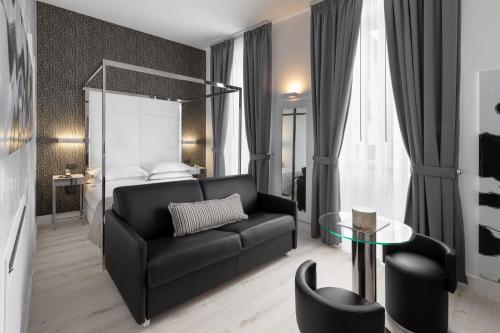 a living room with a black couch and a bed at LHP River Club in Florence