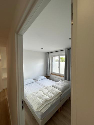 un lit dans une chambre avec une fenêtre dans l'établissement Maison T3 proche MER - Ideal en famille ou entre amis, à La Forêt-Fouesnant