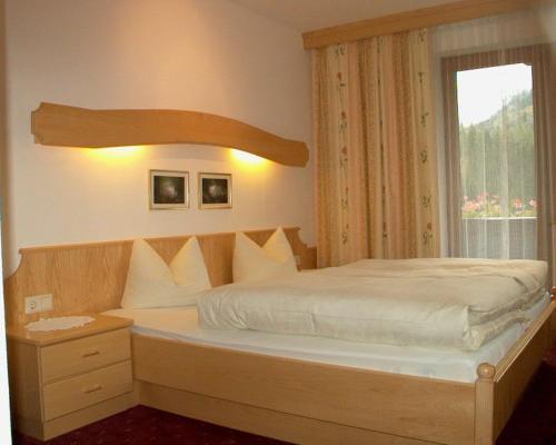 a bedroom with a large bed with a window at Gästehaus Elfriede in Gerlos