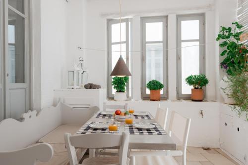 a white dining room with a table and chairs at House of the sea in Naousa