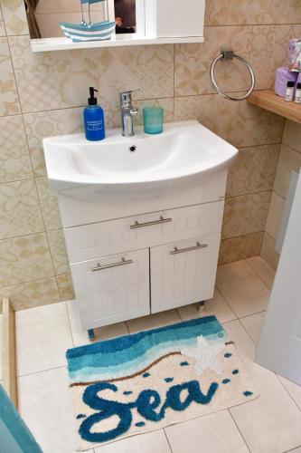 a bathroom with a sink and a bathroom rug at Mitsakos Golden Villa in Egina
