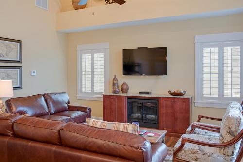a living room with a leather couch and a television at Seaside Serenity in Corolla