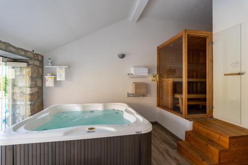 a large bath tub in a bathroom with a wooden floor at Villa Joe in Čilipi