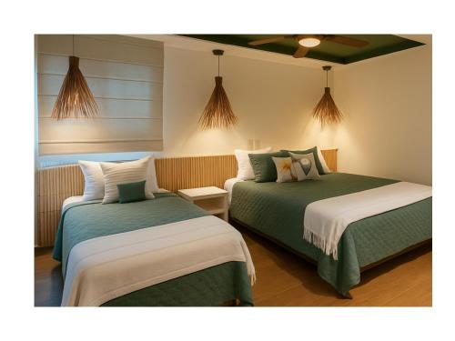 two beds with green and white sheets in a room at Palmares, Casa de praia in Búzios