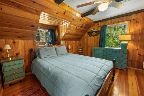 ein Schlafzimmer mit einem Bett und einem Deckenventilator in der Unterkunft Bear Cub Cabin with Hot Tub, Outdoor Patio w BBQ! in Big Bear City Airport
