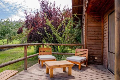two chairs and a table on the porch of a cabin at San Francisco Lodge in Los Andes
