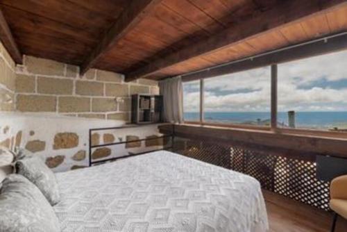 a bedroom with a bed with a view of the ocean at F tamaide in San Miguel de Abona