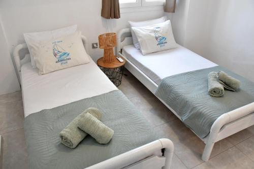 two beds in a room with towels on them at Mitsakos Golden Villa in Egina