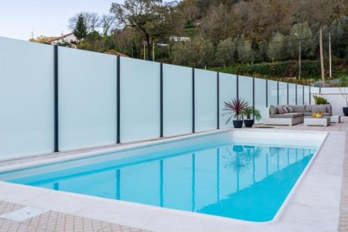 een zwembad met een hek eromheen bij Casa do Moinho Vedro in Quintiães