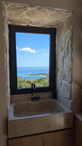 a bathroom with a large sink and a window at Paradisea Rocco's Villa in Taormina