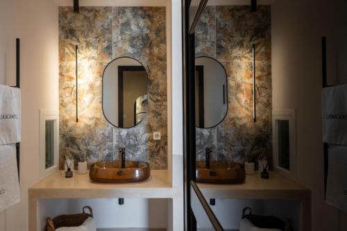 a bathroom with two sinks and two mirrors at Socrates Apartments in Skala Kefalonias