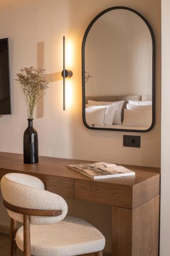a bedroom with a desk with a mirror and a bed at Elèa Concept Hotel & Suites in Gouves