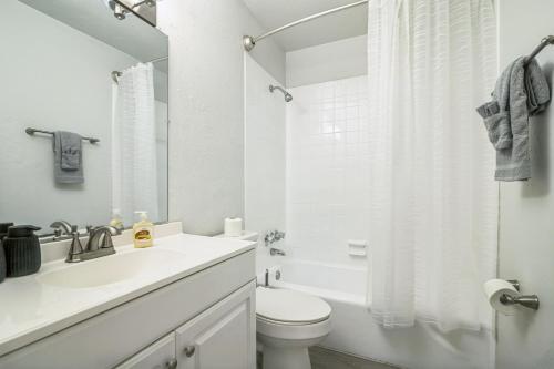 a white bathroom with a toilet and a sink at The Trails M262 I Spacious 2 Bed 2 Bath in Gainesville