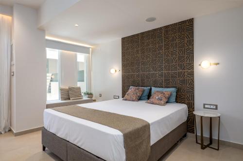 a bedroom with a large bed and a wall at Socrates Apartments in Skala Kefalonias