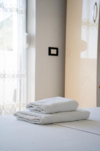 a stack of towels sitting on a counter in a bathroom at Liora Seaview Apartments in Shëngjin