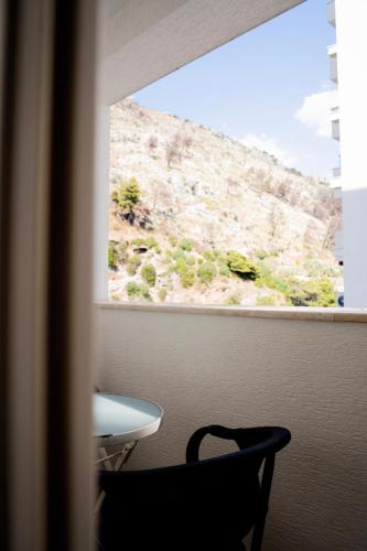 a view of a table and a chair looking out a window at Liora Seaview Apartments in Shëngjin