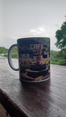 a coffee cup sitting on top of a wooden table at Eco lodge finca magdalena in Altagracia