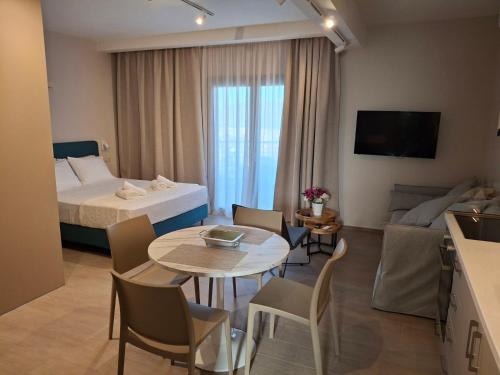 Una habitación de hotel con una cama, una mesa y sillas. en Theasis Deluxe, en Lefkada